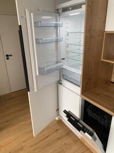 コシツェにあるYour home 17 with parkingのキッチンにあるドアが開いたままの空の冷蔵庫