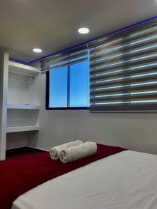 a bedroom with a bed with two towels on it at Posada Restaurant La Guaricha in Catia La Mar +87 photos