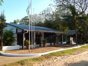 un edificio con una bandera delante de él en Cabañas Los Troncos en Ituzaingó