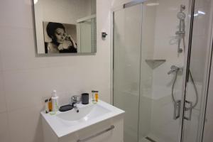 a white bathroom with a sink and a shower at MAROVA LUXURY APARTAMENT Caraiman VIEW in Buşteni +27 photos