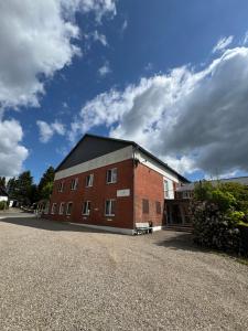 a large red brick building with a sky in the background at Medelby Inn in Medelby