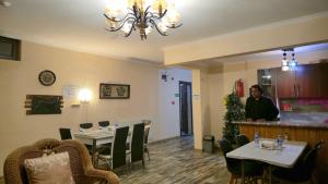 a woman standing in a restaurant with tables and chairs at Kashmiri kitchens hotel in Gudauri +49 photos