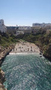 eine Gruppe von Menschen an einem Strand in der Nähe des Wassers in der Unterkunft La Bouganville in Mola di Bari