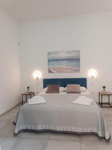 a bedroom with a large bed with two side tables at Clio's House - Mondello in Mondello