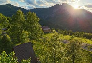 耶蒂斯特Tjentiste A-frame cabin的田野中的一栋房子，背景是群山