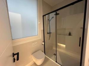 a bathroom with a toilet and a glass shower at Bilbao City Center in Bilbao