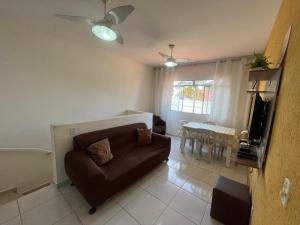 a living room with a couch and a television at Casa 1 km da Praia Enseada com Garagem in Guarujá