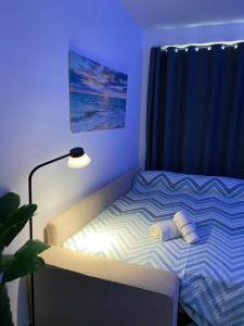 a bedroom with a bed with a lamp next to it at Apartamento Las Sirenas in Chipiona