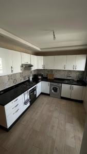 a large kitchen with white cabinets and a dishwasher at Appartement centre ville kenitra in Kenitra