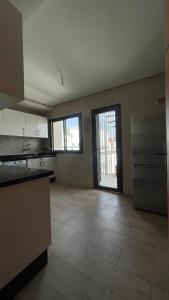 an empty room with a kitchen with a refrigerator at Appartement centre ville kenitra in Kenitra +10 photos
