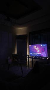 a living room with a large screen tv in the dark at Appartement centre ville kenitra in Kenitra