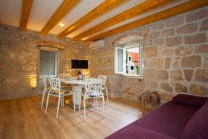 a living room with a table and chairs and a tv at Villa Veli Varos in Split