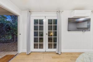 a white room with a sliding glass door at Gympie Cottage Studio in Gympie