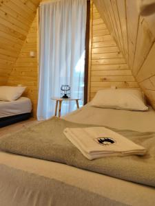 a bedroom with two beds and a window at Vikendica Monte Pino Romanija in Sokolac