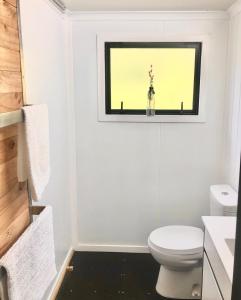 a bathroom with a toilet and a window at Gorgeous Glamping in Karangahake in Karangahake +11 photos