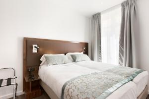 Un dormitorio con una cama grande y una ventana. en Le Trente, en París