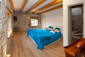 sypialnia z niebieskim łóżkiem i kamienną ścianą w obiekcie Villa Veli Varos w Splicie