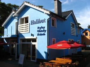 a blue building with an umbrella in front of it at Halibut in Stegna