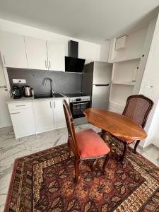 a kitchen with a table and two chairs and a sink at Studio 1 room 25 sqf in Oltingue