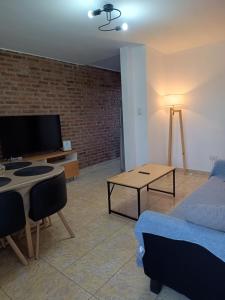 a living room with a bed a table and a tv at Departamento amplio en zona tranquila cercana al centro de Ezeiza in Ezeiza