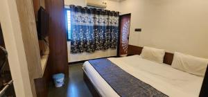 a small bedroom with a bed and a television at Hotel Sanskruti in Nagpur