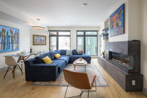 een woonkamer met een blauwe bank en een open haard bij Timber Fox located downtown Winter Park 1307 in Winter Park