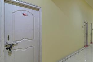 a white door with a sign on it in a room at Hotel O Green Hills Resort in Sopāra