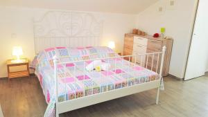 a bedroom with a bed with a pink and blue quilt at Apartment Jaz in Rogoznica