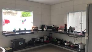 a kitchen with a sink and a counter with pots and pans at Beach House! in Ilhéus