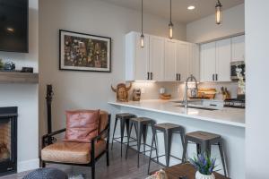 a kitchen with a bar and some stools at Hideaway Station TS 23 - New in Downtown Winterpark in Winter Park