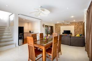 a dining room and living room with a table and chairs at Coconuts Villa Balangan Beach in Jimbaran
