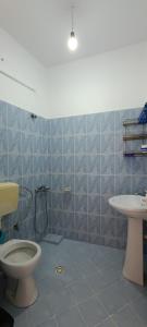 a bathroom with a toilet and a sink at Sunset Boulevard Rooms in Qeparo