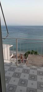 a balcony with a view of the beach and the ocean at Sunset Boulevard Rooms in Qeparo +1 photo