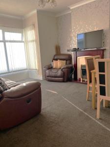 a living room with a couch and a chair and a fireplace at Stylish and Spacious two-bedroom Apartment in Blackpool