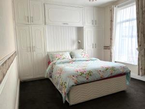 a white bedroom with a bed and a large window at Stylish and Spacious two-bedroom Apartment in Blackpool