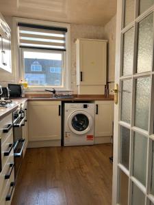 a kitchen with a washing machine and a window at Stylish and Spacious two-bedroom Apartment in Blackpool