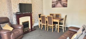 a living room with a table and a fireplace at Stylish and Spacious two-bedroom Apartment in Blackpool