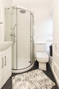 a bathroom with a shower and a toilet and a rug at Stunning 2-BR Home Gravesend Town Centre, Kent in Gravesend