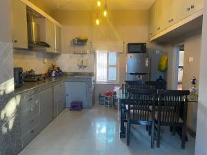Una cocina con refrigerador y una mesa y sillas. en Gulariya Home Stay, en Bākhri Kharka