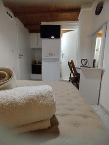 a room with a bed and a kitchen with a table at MMrooms 1 διπλό κρεβάτι in Tinos Town