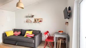 a living room with a gray couch and red chairs at Casa Mel-Mina São Domingos-Praia fluvial-Terraço-3km-arcondicionado in Mértola