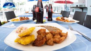 a table with plates of food and bottles of soda at Grand Pacific Ocean in Tonsupa