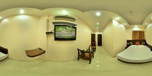a living room with a tv in a heart shaped wall at Amax Inn in New Delhi