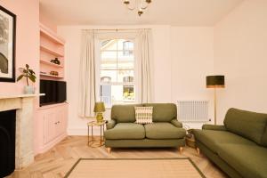 a living room with a green couch and a fireplace at The Corner by the Castle in Rochester