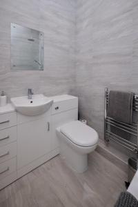 a white bathroom with a toilet and a sink at The Corner by the Castle in Rochester +29 photos