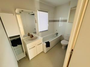 un bagno bianco con lavandino e WC di A l'orée de Valence -L'orchidée- Île parc Girodet a Bourg-lès-Valence Altre 10 foto