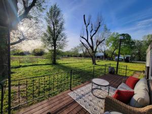 a patio with a couch and a table on a deck at Grandma's House at Rosewood Lodge in Iola