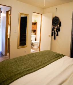 a bedroom with a bed and a bathroom with a toilet at Grandma's House at Rosewood Lodge in Iola