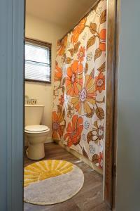 a bathroom with a toilet and a flower patterned wall at Grandma's House at Rosewood Lodge in Iola +46 photos