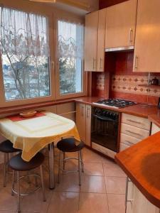 a kitchen with a table and a table and chairs at Apartament Pod Pawiem in Olsztyn